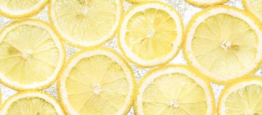 Arka planda hava kabarcıkları olan limon dilimleri.