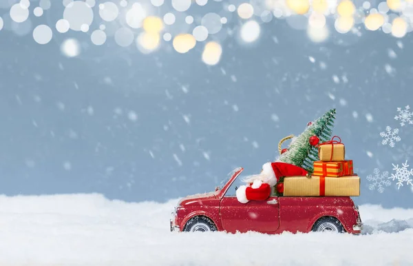 Weihnachtsmann Rotem Auto Liefert Weihnachtsbaum Und Geschenke Vor Verschneitem Hintergrund — Stockfoto