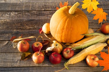 Sonbahar kompozisyonu Ahşap masada elmalı balkabağı mısırı