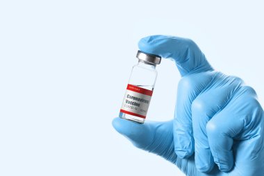 Coronavirus Covid-19 Aşısı. Doktor mavi arka planda enjeksiyon için tıbbi tüpü bekletin.