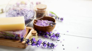 Beyaz bir masada lavanta çiçekli lavanta sabunu ve spa ürünleri..