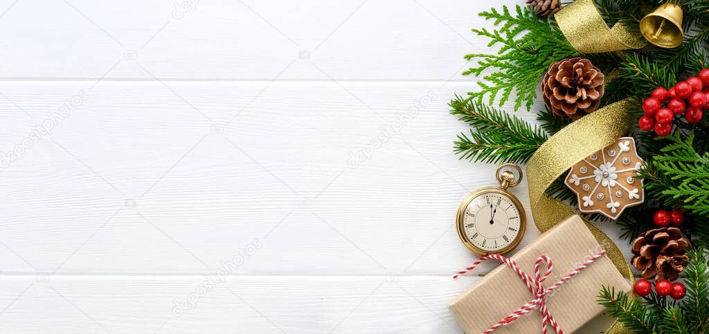 Fir tree branches with pocket watch, christmas decorations and gift box on white wooden background
