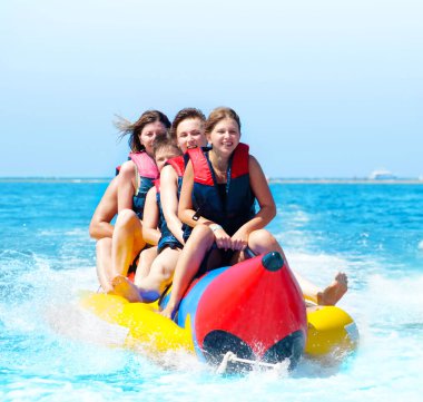 İnsanlar muz teknesine biniyor.