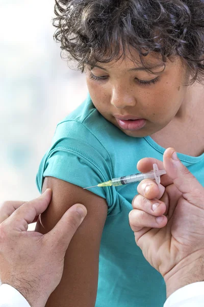 Вакцинация. Мальчик получает вакцинацию от профессионального медицинского работника, сосредоточиться на плече — стоковое фото