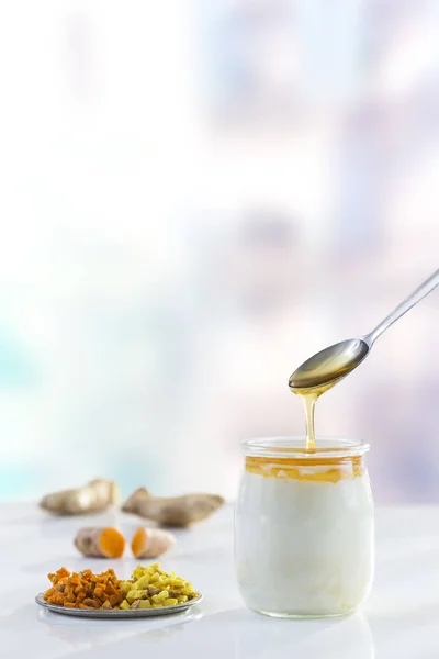 Du yaourt au miel. Yaourt grec au miel dans un pot en verre avec des produits à base de miel — Photo