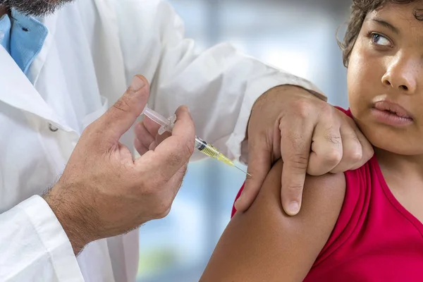 Vaccination. Young boy receiving vaccination immunisation by professional healthkid looking at doctor — Stock Photo, Image