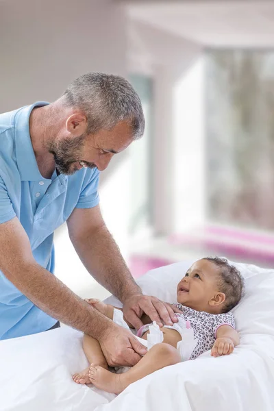 Baby Changing. Loving father changing diaper of his baby daughter.,Little child, girl on changing table in bathroom with rattle toys. Happy dad. — Stock Photo, Image