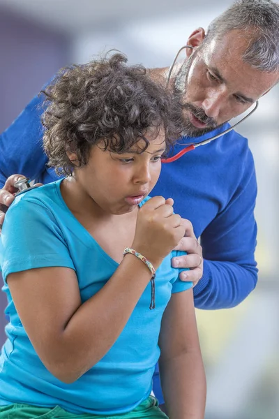 Gripe juvenil. doctor examina un joven adolescente resfriados escuchar los pulmones con un estetoscopio mientras él está tosiendo —  Fotos de Stock