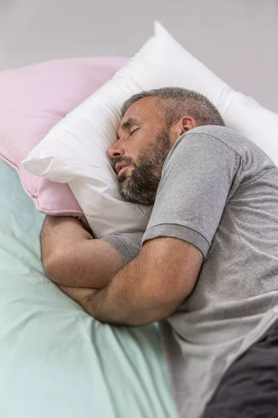 Feliz de dormir. Joven durmiendo en su cama con los ojos cerrados —  Fotos de Stock