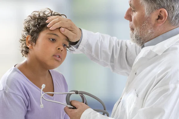 Febre infantil. pediatra masculino verificando adolescente menino cabeça temperatura com a mão — Fotografia de Stock