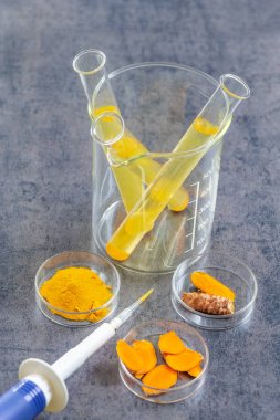 Curcuma'da Sağlık Resaerch. kayrak arka plan üzerinde zerdeçal tozu ve zerdeçal kökü ile mater ve curcuma ile test tüpü