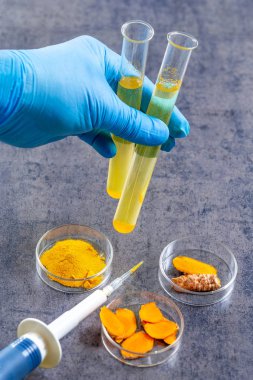 Curcuma'da Sağlık Resaerch. Beyaz arka plan üzerinde zerdeçal tozu ve zerdeçal kökü ile mater ve curcuma ile test tüpü