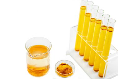 Curcuma'da Sağlık Resaerch. Beyaz arka plan üzerinde zerdeçal tozu ve zerdeçal kökü ile mater ve curcuma ile test tüpü