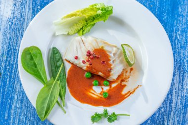 Salata ile kırmızı biber soslu buğulanmış balık Tabağı