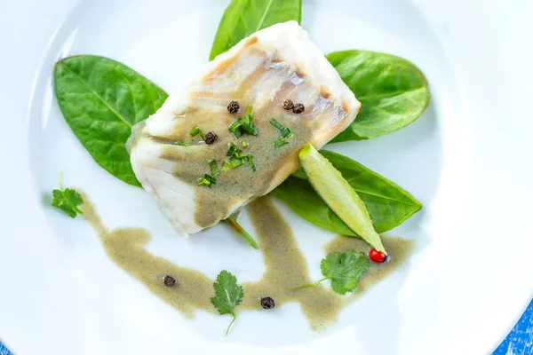 Тарелка из рыбы на пару с соусом соррель с салатом — стоковое фото