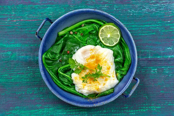 Filé de bacalhau com arroz e espinafre enfeite com caril, em panela vintage sobre fundo de madeira — Fotografia de Stock