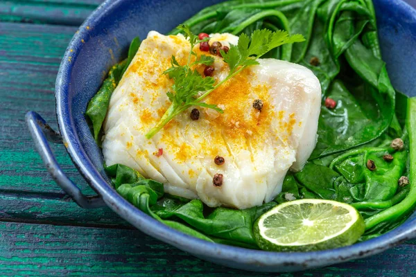 Filé de bacalhau com arroz e espinafre enfeite com caril, em panela vintage sobre fundo de madeira — Fotografia de Stock