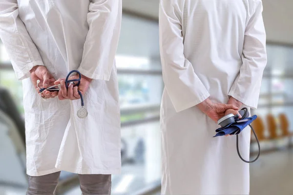 Clínica, profissão, pessoas, saúde e medicina conceito médicos andando ao longo das mãos corredor hospitalar na parte de trás segurando estetoscópio — Fotografia de Stock