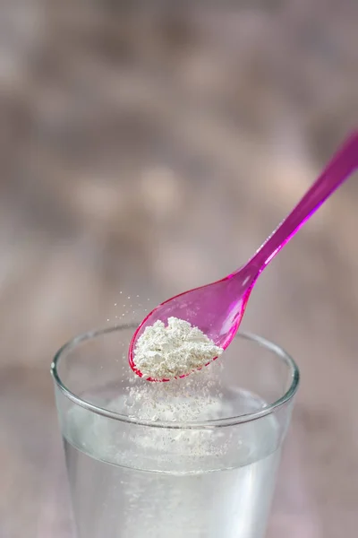 Sebuah minuman dari tanah liat, sendok tanah liat putih di kaca dari air tawar blur background — Stok Foto