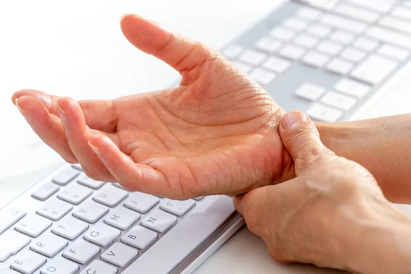 Office syndroom concept. Close-up vrouw houdt haar pols pijn van het gebruik van computer lange tijd. — Stockfoto