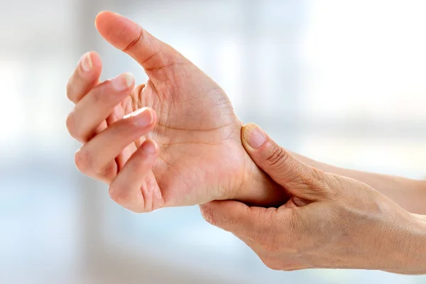 Dolor agudo en la muñeca de una mujer sobre fondo blanco. fondo de oficina. Asistencia sanitaria, estilo de vida . — Foto de Stock