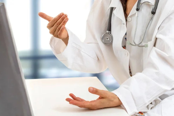 Médico femenino explicando los síntomas del paciente o haciendo una pregunta mientras discuten juntos en una consulta . — Foto de Stock