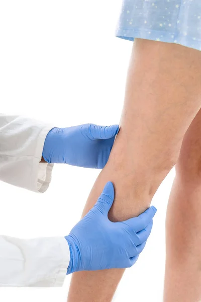 Flebólogo inspeccionar una pierna de las mujeres en busca de venas varicosas sobre fondo blanco — Foto de Stock