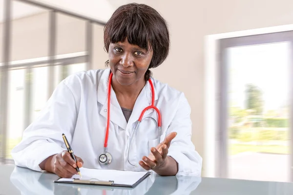 Лікар з жестами, пояснюючи діагноз, що сидить на білому столі в лікарні , — стокове фото