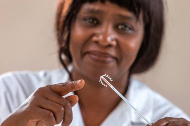 Afrikalı, Amerikalı doktor bakır bobin cihazı gösteriyor. Ofisinde Ud.