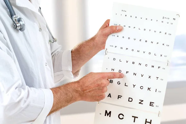 Οφθαλμίατρος ελέγχει την όραση των ασθενών, δείχνοντας γράμματα, εξέταση ματιών στο γραφείο — Φωτογραφία Αρχείου