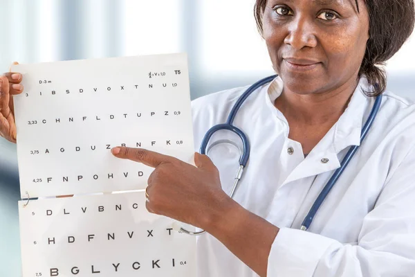 Oftalmologista verificando a visão do paciente, apontando letras, exame de olhos no escritório — Fotografia de Stock