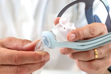 Uyku apnesi tedavisi uygulayan ve Obstrtive Sleep Apnea Sendromu olan hastalar için horlayan doktor sürekli pozitif hava yolu basınç cihazı Cpap 'a bağlı.