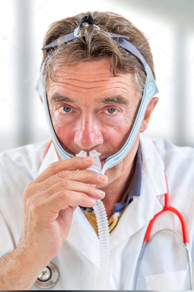 Doctor demonstrating Treatment of sleep apnea and snoring for patient suffering from Obstructive Sleep Apnea Syndrome OSAS connected to a continuous positive airway pressure device CPAP