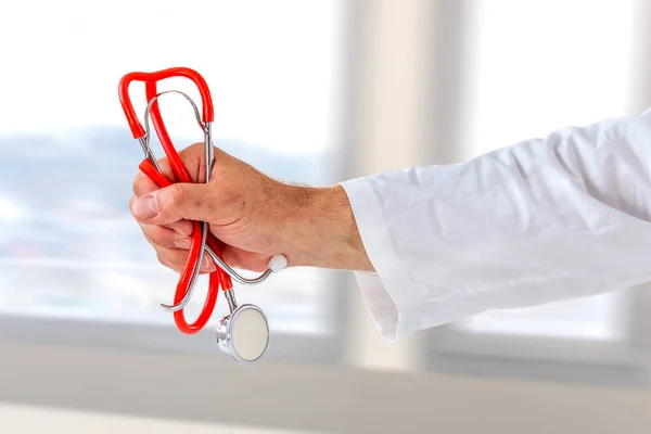 Close-up van de hand van een arts met een stethoscoop uitgestrekt naar de kijker. Gezond levensstijl concept. Kopieerruimte. — Stockfoto