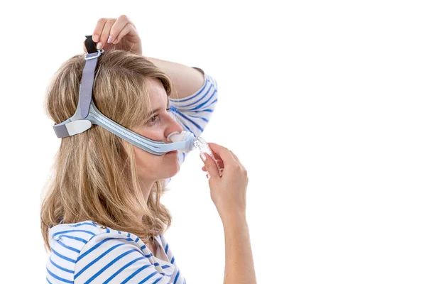 Woman trying to wear CPAP mask, sleep apnea therapy.Profile view — Stock Photo, Image