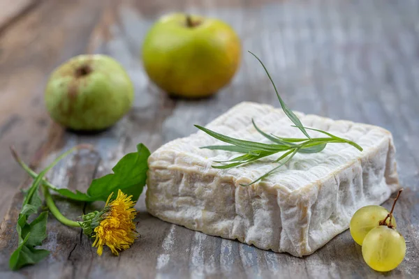 Un bloc de fromage Pont-l eveque Normandie française reposant sur une planche de bois — Photo