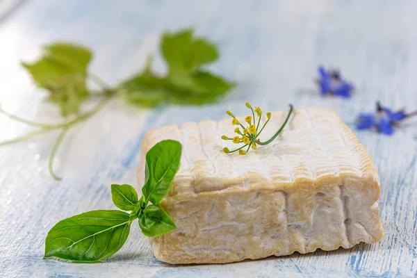 Un bloc de fromage Pont-l eveque Normandie française reposant sur une planche de bois — Photo