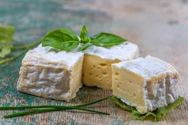 Ein Block Pont-l eveque französischer Käse aus der Normandie ruht auf einem Holzbrett — Stockfoto