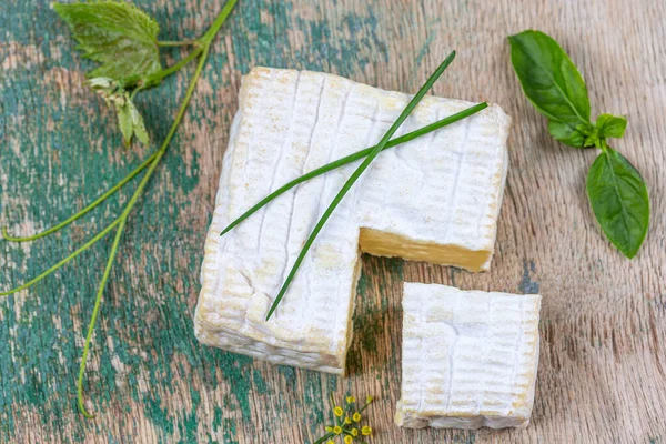 A block of Pont-l eveque French Normandy cheese resting on wooden board — Stock Photo, Image