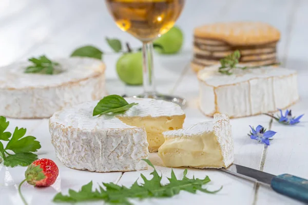 Değişik peynir çeşitleri. Lezzetli ve taze peynir, bir bardak elma şarabı, beyaz ahşap arka plan. — Stok fotoğraf