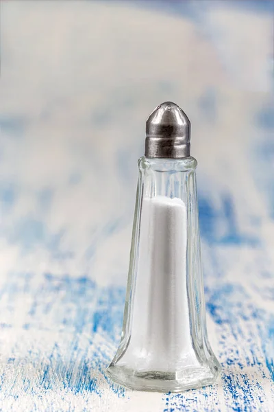 Salt shaker isolado no fundo de madeira branco e azul — Fotografia de Stock