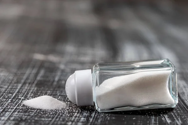 Salt shaker isolated on white and white wooden background — Stock Photo, Image