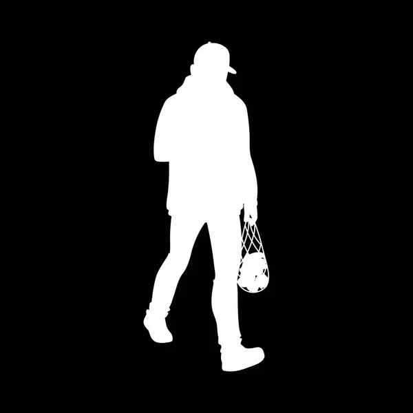 Erwachsener Mann in warmer Jacke und Baseballkappe beim Gehen. weiße Silhouette isoliert auf schwarzem Hintergrund. Frontansicht. Monochrome Vektorillustration eines Mannes, der mit einem Paket Obst aus dem Supermarkt zurückkommt — Stockvektor