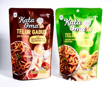 Jakarta, Endonezya - 8 Eylül 2025 - Muhteşem Endonezya birleşimi Kata Oma markası telur palmiye şekeri ve kavrulmuş mısır aromalı yiyecek ürünleri beyaz arka planda izole edildi.