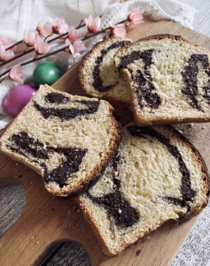 Cozonac, Romanya geleneksel Paskalya tatlı ekmeği tatlısı. Tahta kesme tahtasıyla tatlı ekmek kesmek ve arka planda Paskalya yumurtaları.