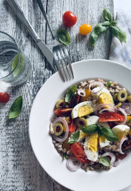 Haşlanmış yumurtalı ev yapımı salata, taze sebze ve ahşap arka planda fesleğen. Hecelenmiş salata. Sağlıklı yiyecekler. Tam üstte.