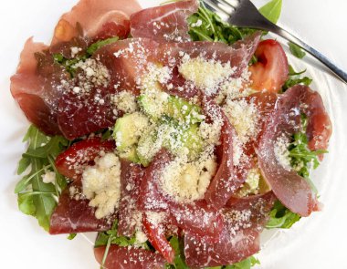 Roket salatası ve parmesan peynirli nefis taze bresaola. Sağlıklı gıda konsepti. İtalyan yemeği. Yakın plan..