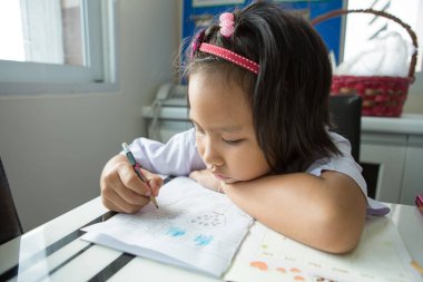 Asyalı öğrenci ev ödevi yapıyor.