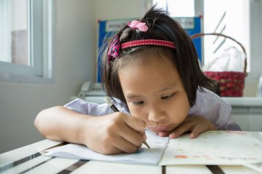 Asyalı öğrenci ev ödevi yapıyor.