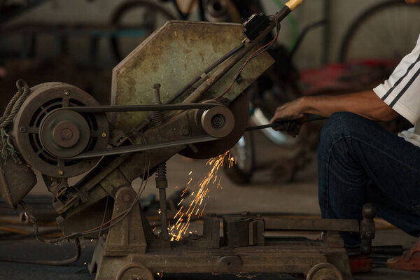 The man worker welding metal with sparks.